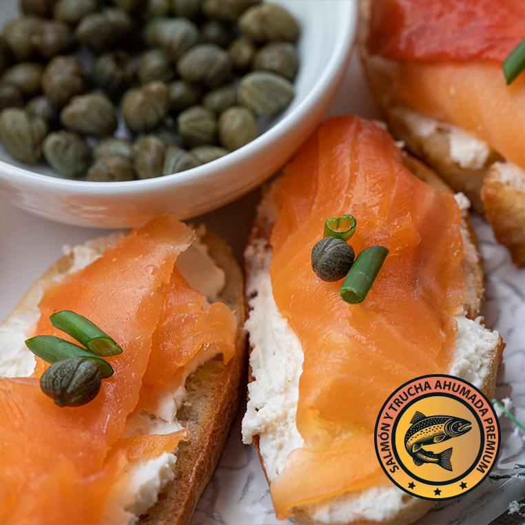Canapés de salmón ahumado con crema y alcaparras sobre pan artesanal